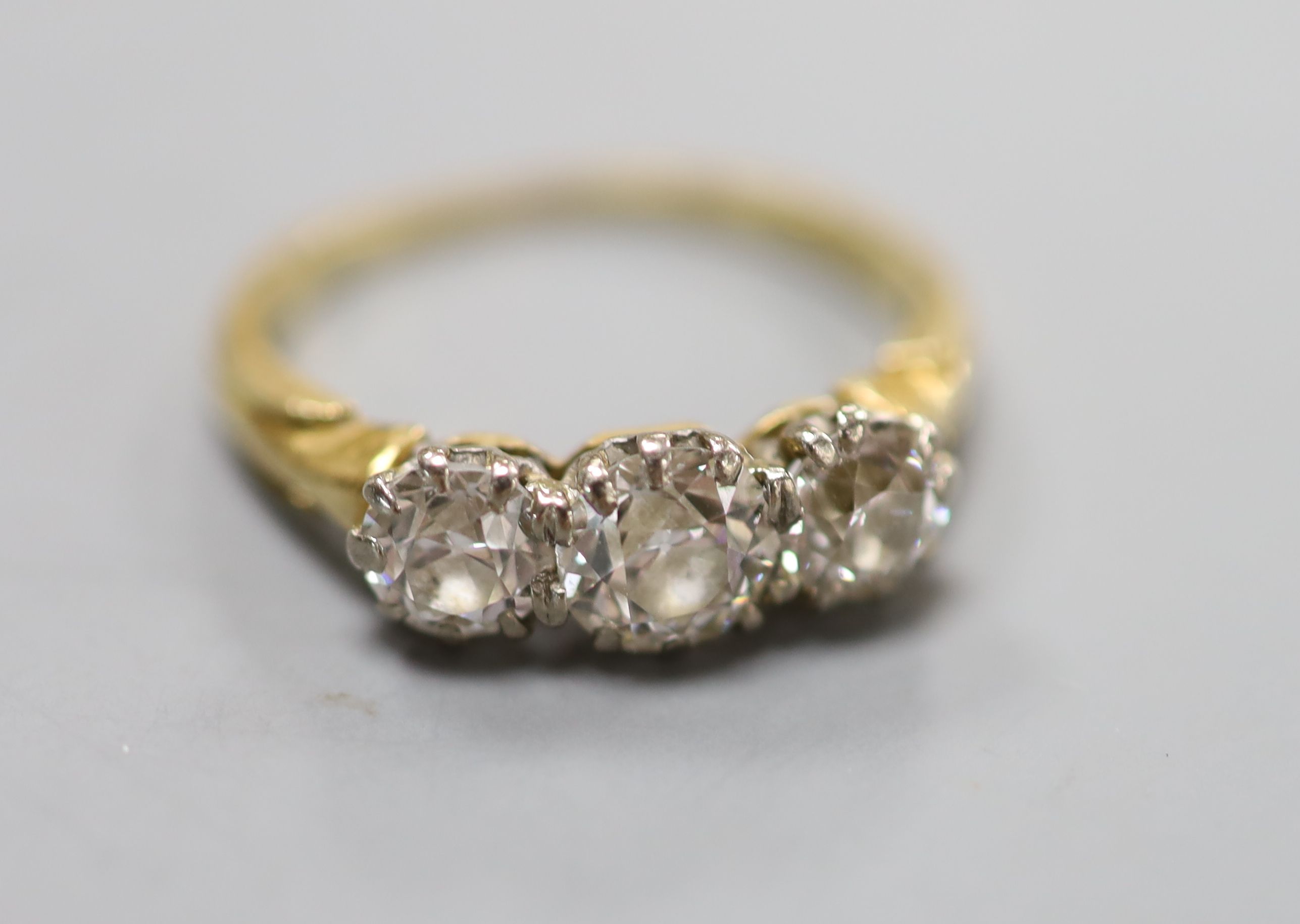 A yellow metal and three stone diamond ring, size L, gross weight 3.3 grams